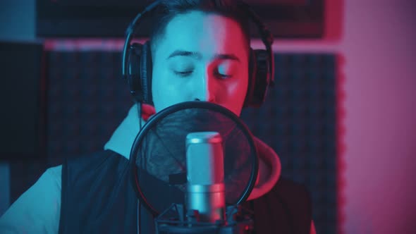 A Man Rapping in the Studio and Recording His Track