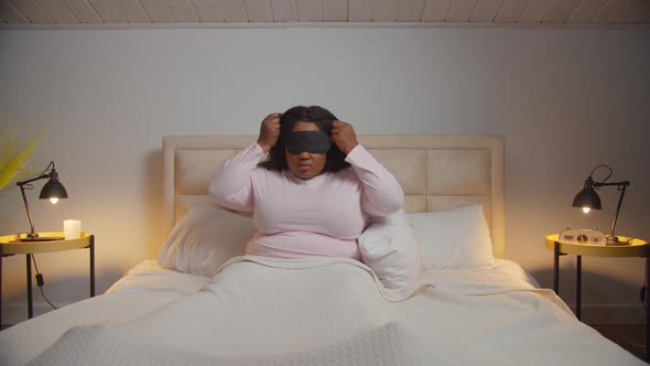 Tired Female Putting Sleep Eye Mask Bed