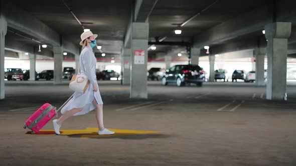 Woman in Mask with Pink Luggage Just Arrived To Her Vacation. COVID-19 Travels