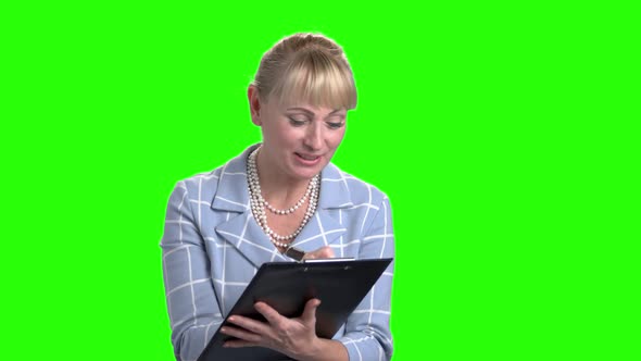 Smiling Woman Making a Note on Clipboard