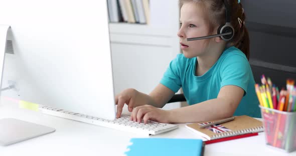 Little Girl in Headphones is Typing on Computer Keyboard and Looking at Screen  Movie