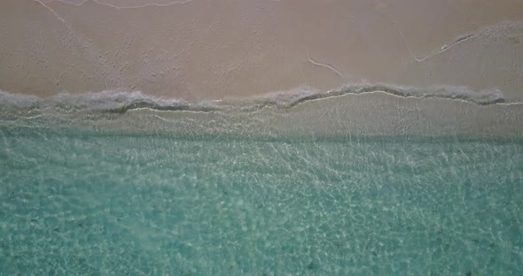 Wide angle overhead island view of a white paradise beach and blue sea background in colorful 4K