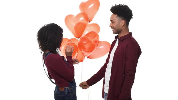 Slow Motion Young Handsome African American Surprise His Girlfriend with Heart Balloon on White