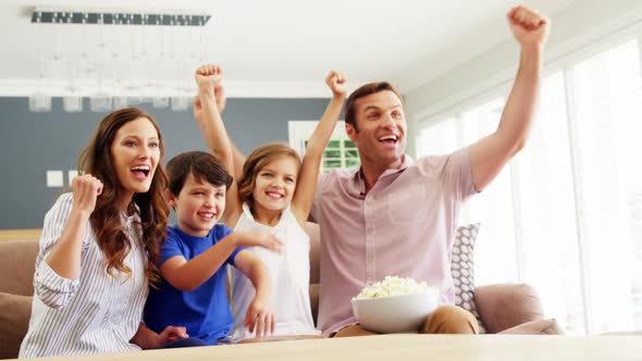 Happy family watching tv in living room