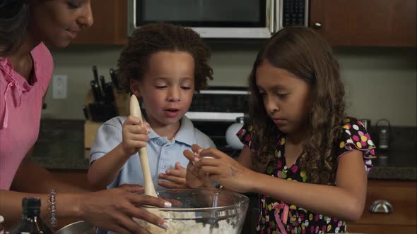 Slow motion of girl cracking egg on side of bowl