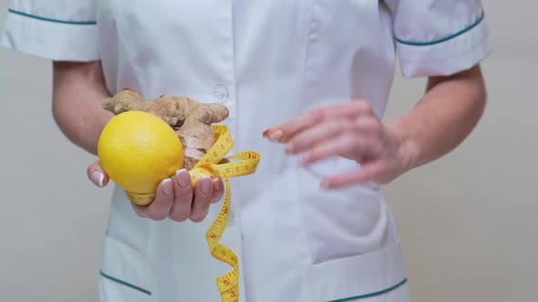 Nutritionist Doctor Healthy Lifestyle Concept - Holding Ginger Root, Lemon Fruit and Measuring Tape