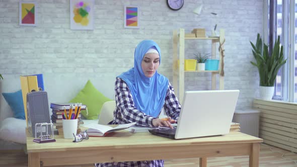 Beautiful Young Muslim Woman in Hijab Studying in Modern Apartments