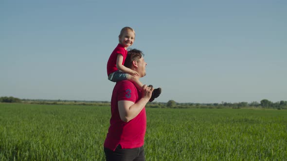 Dad Piggybacking Laughing Baby Girl in Nature