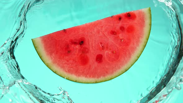 Super Slow Motion Shot of Falling Fresh Watermelon Slice Into Water at 1000Fps.