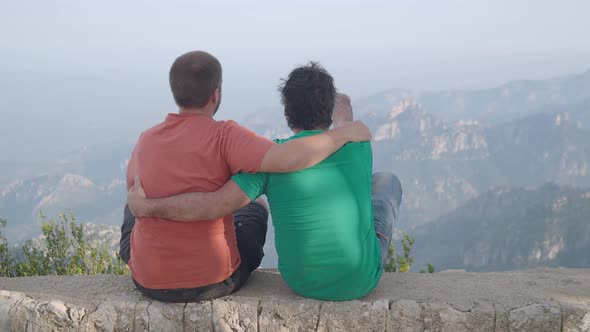 Gay Couple of Men with Their Backs Turned Caressing and Observing Nature