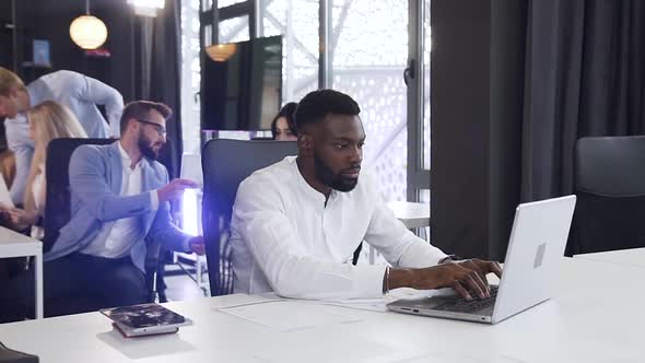 Bearded African American Businessman Working with Papers and Computer at the Office Table