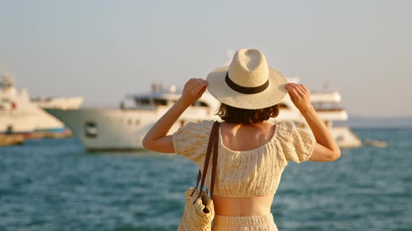 Young woman in hat looking at the sea. Split, Croatia