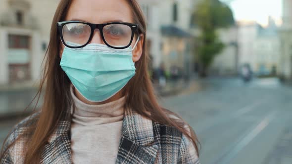 Pandemic Protection of the Covid-19 Coronavirus. Portrait of a Woman in a Coat, Glasses and a