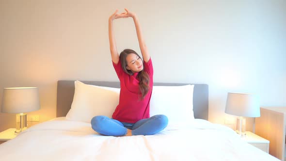 Asian woman relax on bed in bedroom interior