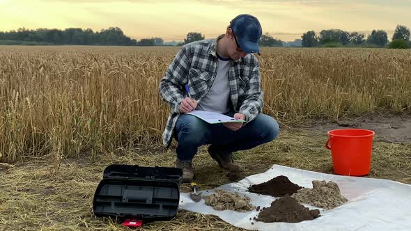 Agronomist Taking Notes in Sampling Information Sheet at Field at Dawn