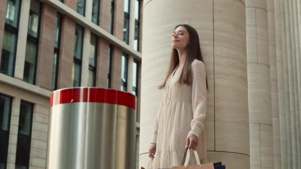 Woman Standing by Pillar after Shopping