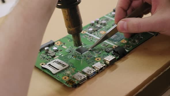Closeup of a Technician Repairing a Computer Chip with a Soldering Iron