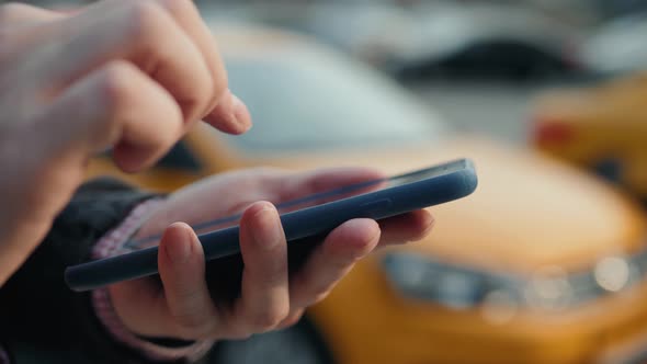 Elegant Businessman Checking Taxi Application App on Mobile Phone While Walking Outside Airport