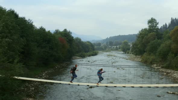 Aerial Nature Bridge Couple Running on Having Fun Close Small Mountain River