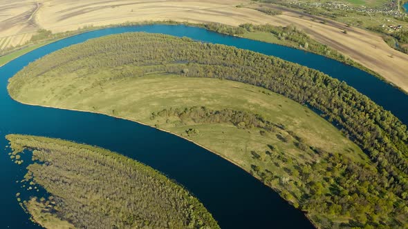 Aerial View Green Forest Woods And Curved River Landscape In Sunny Spring Day