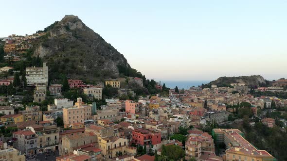 Old town spread over the hills. Drone descending; afternoon shot. Mediterranean Sea in the backgroun