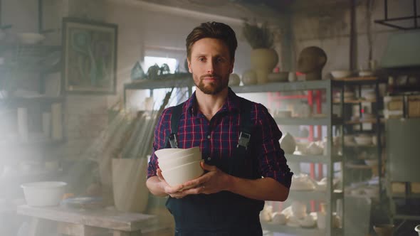 Man Is Holding Clay Pots In Workshop