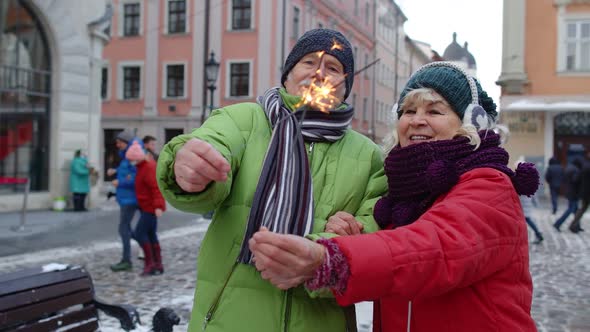 Senior Couple with Burning Sparklers Bengal Lights Celebrating Anniversary on City Center Street