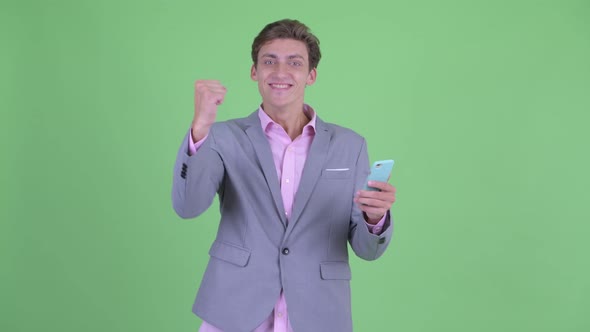 Happy Young Businessman Using Phone and Getting Good News