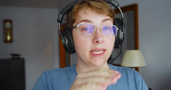 A Teenager Boy in a Headset is Broadcasting Video From Home