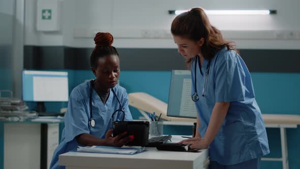 Medical Team of Nurses Using Tablet with Touch Screen