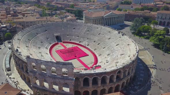 Aerial panoramic view of Arena di Verona, Italy. Drone flies from houses with scooped roofs to Arena