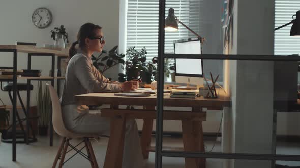 Businesswoman Working on Computer and Using Smartphone at Work