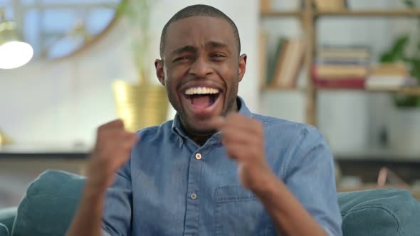 Excited Young African Man Celebrating at Home