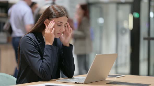 Stressed Businesswoman with Headache at Work