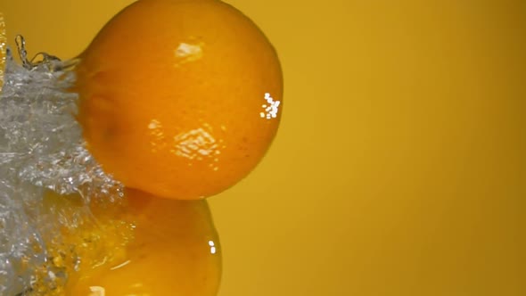 Group of Ripe Oranges are Bouncing Horizontally with Water Splashes