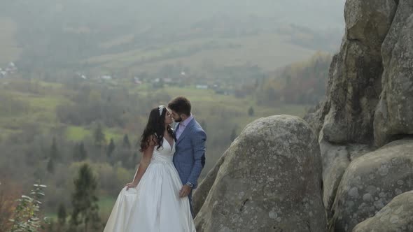 Groom with Bride on a Mountain Hills in the Forest. Wedding Couple