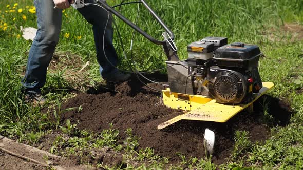 Unrecognizable Farmer Plow Arable Land with Rotary Gasoline Mini Tiller Slowmo