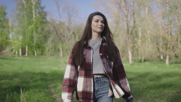 A Beautiful and Carefree Young Woman Walks in the Park in Spring