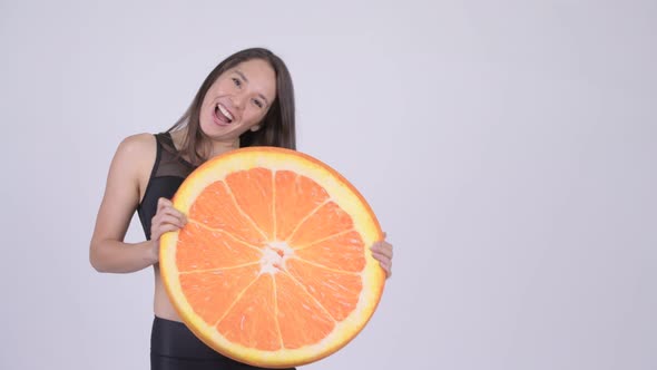 Young Happy Multi-ethnic Woman Ready for Gym with Orange Pillow As Healthy Concept