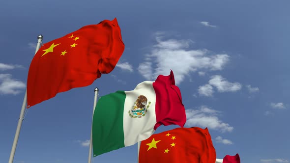 Waving Flags of Mexico and China on Sky Background