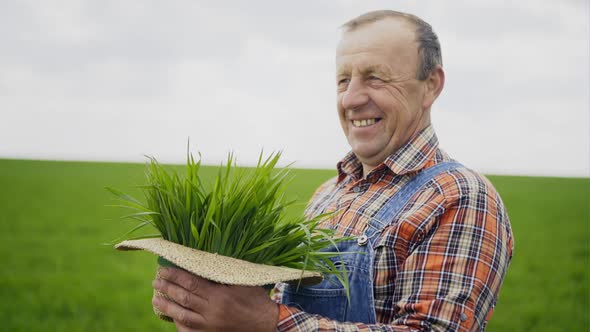 Elderly Male Farmer with Green Plants in His Hat