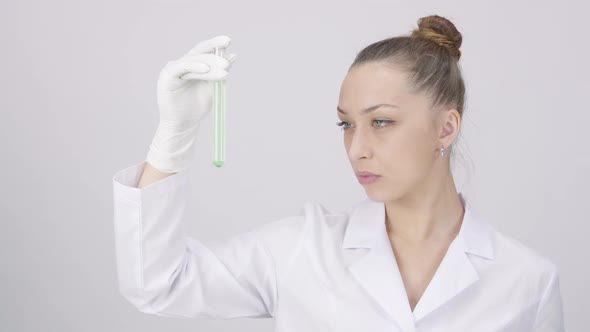 Pretty Scientist Check Test Tube with Green Liquid White Laboratory Background