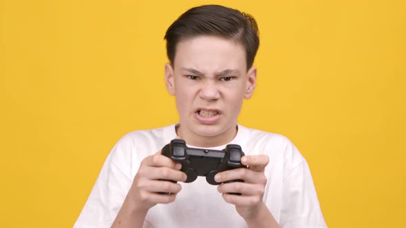 Disappointed Teen Boy Losing Videogame Playing Posing Over Yellow Background