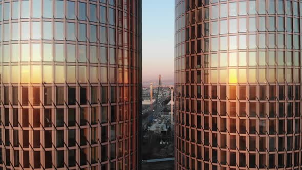 Cityscape in sunset between two glass tower buildings in Riga, Latvia Aerial drone view backwards