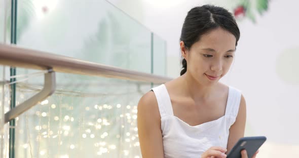 Woman look at mobile phone inside shopping center