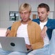 Shocked Male Gay Couple Looking at Laptop Screen and Upset with Bad News While Sitting Together on - VideoHive Item for Sale