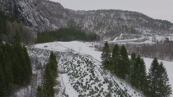 Flight over basin next to mountain slope snowy  beautiful landscape