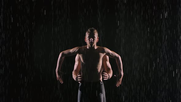 Acrobatic Show in the Rain Performed By Two Professional Male Artists. Shot on the Surface of the