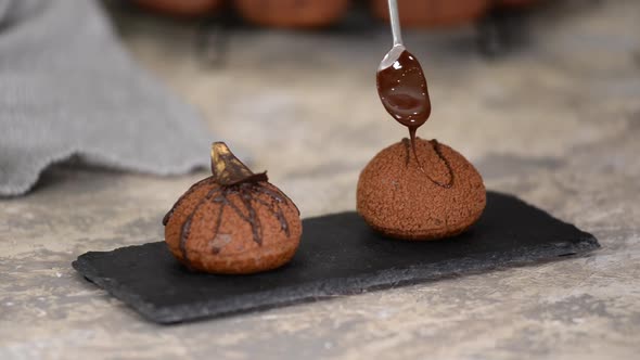 French Dessert Chocolate Choux Au Craquelin. Pouring Chocolate Over the Profiteroles.