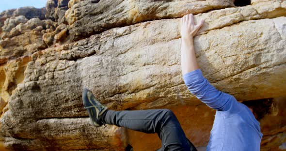 Male hiker climbing rocky mountain in countryside 4k